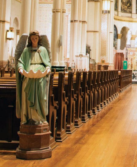 Angel holding a holy water font along the nave