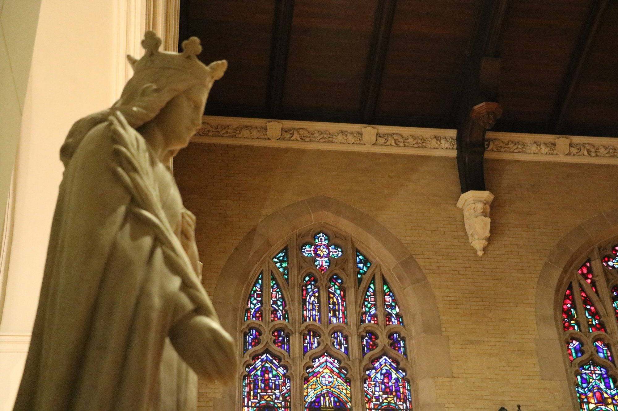 A marble Madonna beneath the nave's stained glass windows